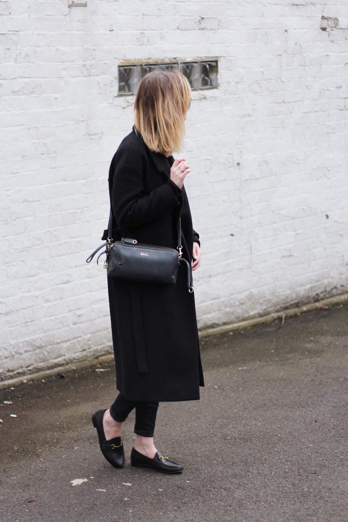 staple-all-black-look-gucci-loafers-cos-belted-coat-d&g-bag